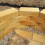 A DIY fire pit uses bricks stacked on top of each other, creating a circle. Bricks are at the bottom, creating a flat surface.