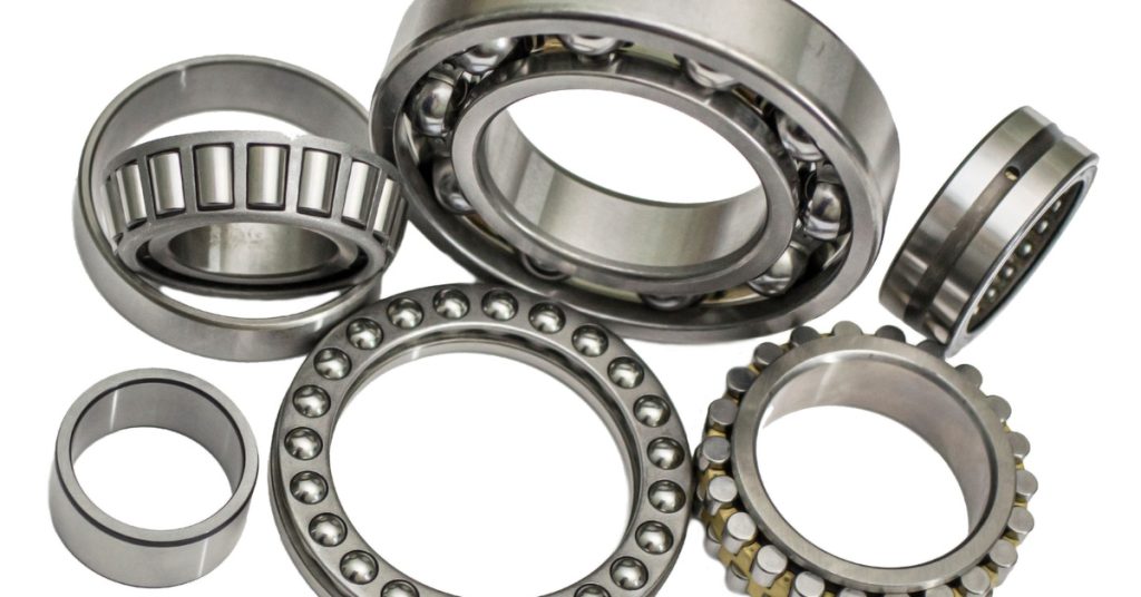 Several Babbitt bearings sit on a white background. Some of them are lying flat, and others are sitting up.